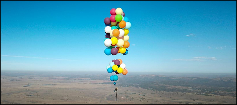 man flies-ballons