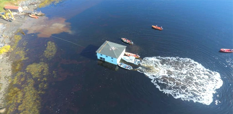 WATCH-this-couple-use-fleet-of-boats-for-floating-their-home-to-new-estate